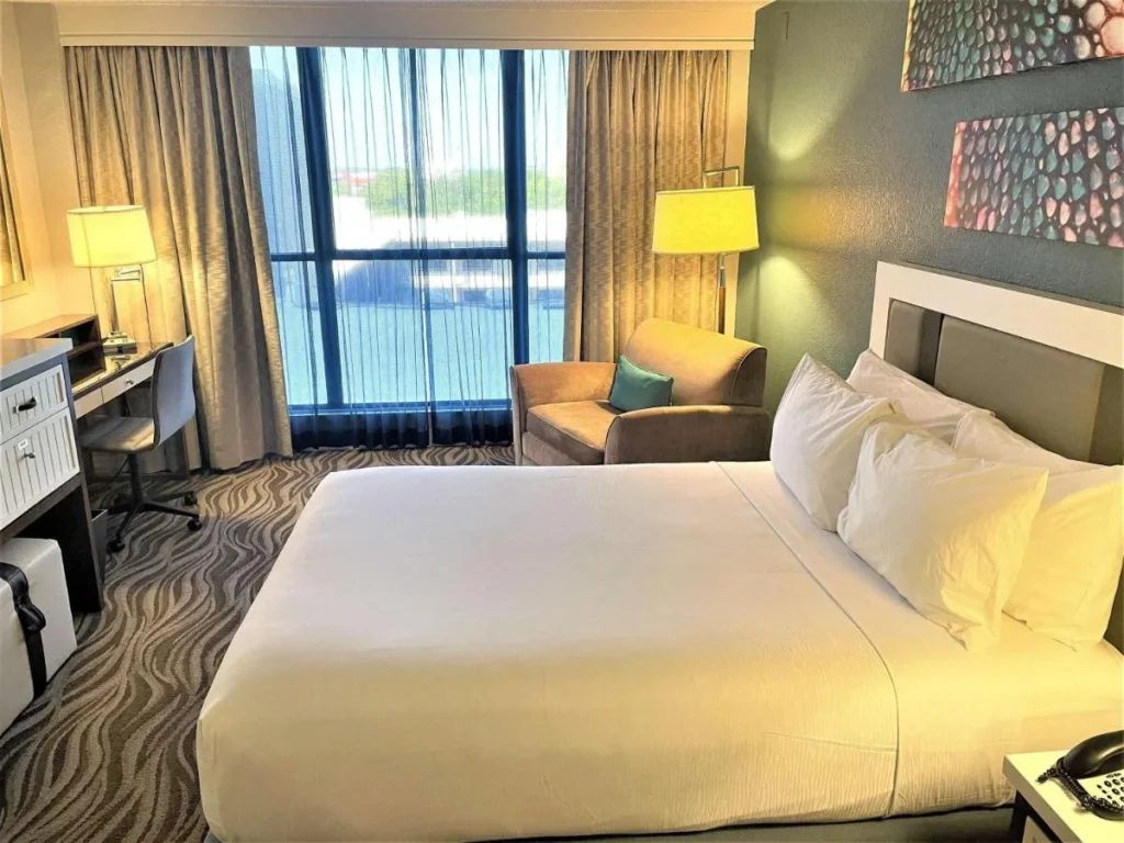 Habitaci&oacute;n King con sill&oacute;n, escritorio y ventana de piso a techo en Wyndham Lake Buena Vista