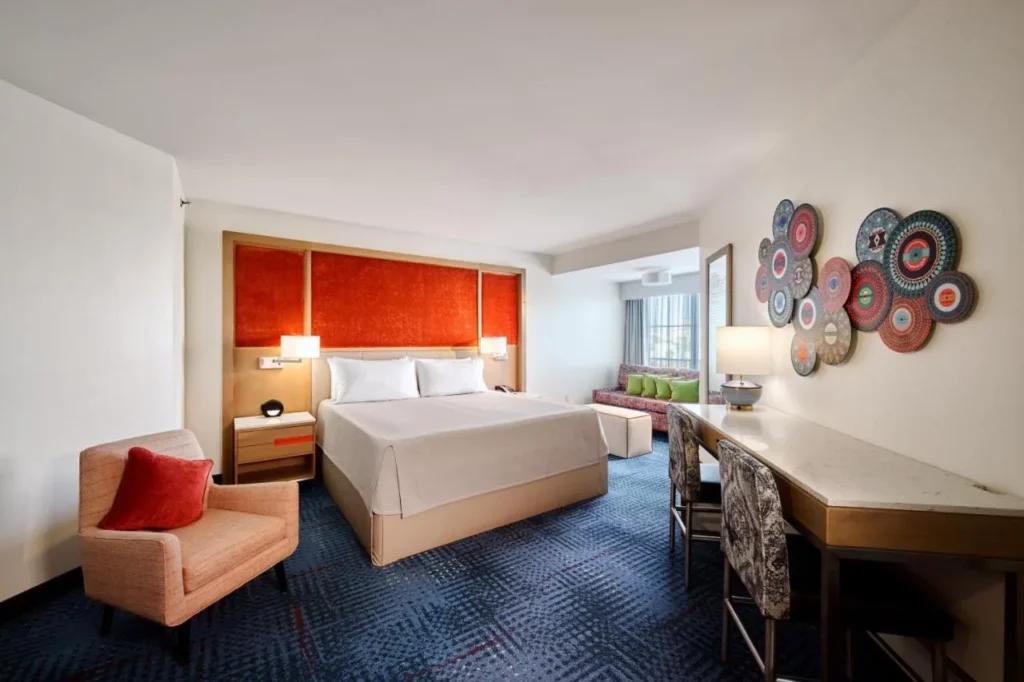 King room with an orange headboard wall and armchair at Universal's Hard Rock Hotel