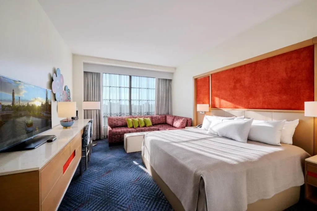 King room with an orange velvet headboard and a sectional sofa at Hard Rock Hotel Orlando