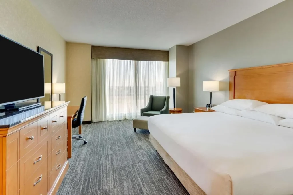 King room with armchair, desk and curtained window at Drury Inn & Suites near Universal