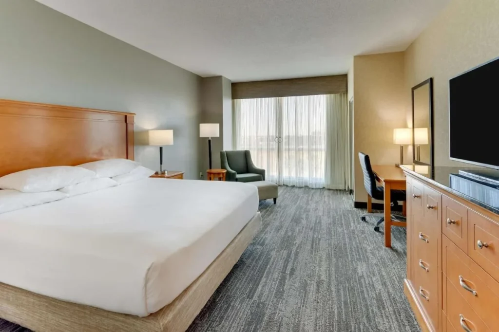 King room with armchair, desk and dresser with TV at Drury Inn & Suites near Universal