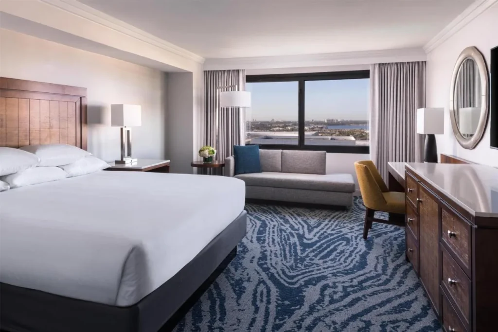 Habitaci&oacute;n con cama king con sof&aacute; chaise, c&oacute;moda y vistas a la ventana del Hyatt Regency Orlando