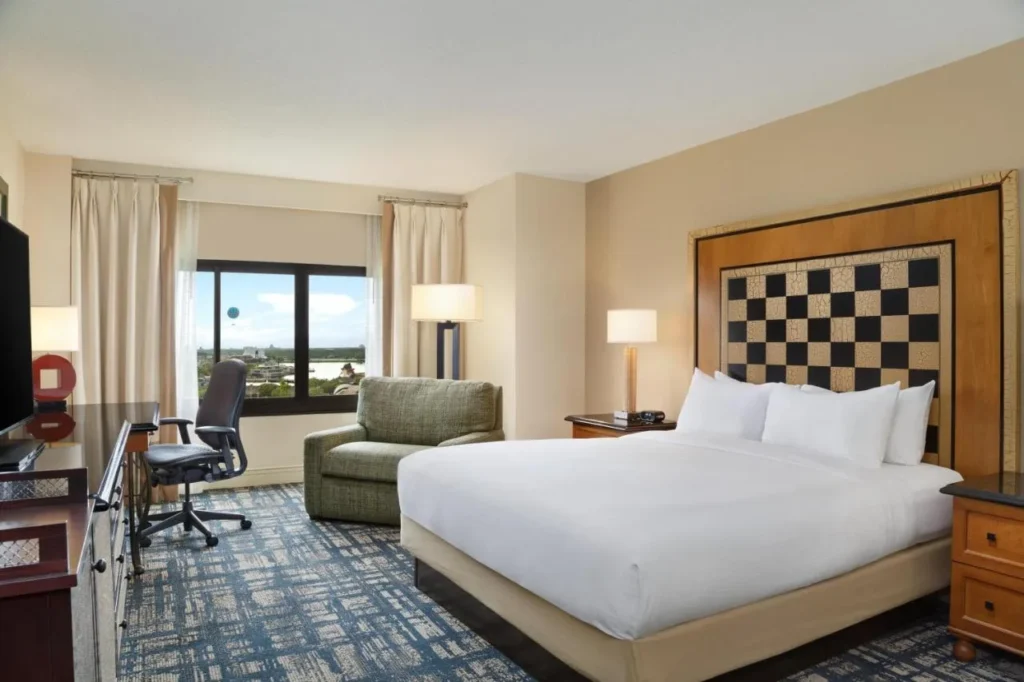 Habitación King con cabecera de tablero de ajedrez y ventana hacia Disney Springs en Hilton Orlando Lake Buena Vista