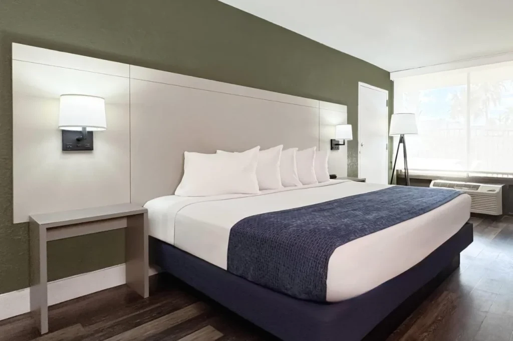 King room with navy bedspread, green accent wall and floor lamp at Wyndham I-Drive Avanti