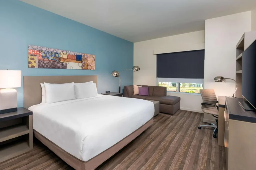 Habitaci&oacute;n con cama king y sof&aacute; seccional y escritorio en Hyatt House Orlando Airport