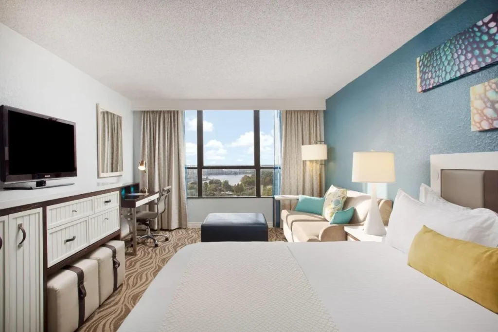 Habitaci&oacute;n King con sof&aacute;, escritorio y ventana con vistas al lago en Wyndham Lake Buena Vista