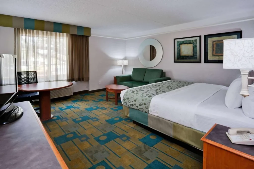 Habitación King con sofá, mesa redonda y alfombra estampada en La Quinta by Wyndham USF Tampa