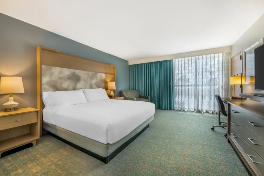 King room with teal curtains and a large window at Holiday Inn Orlando Disney Springs Area