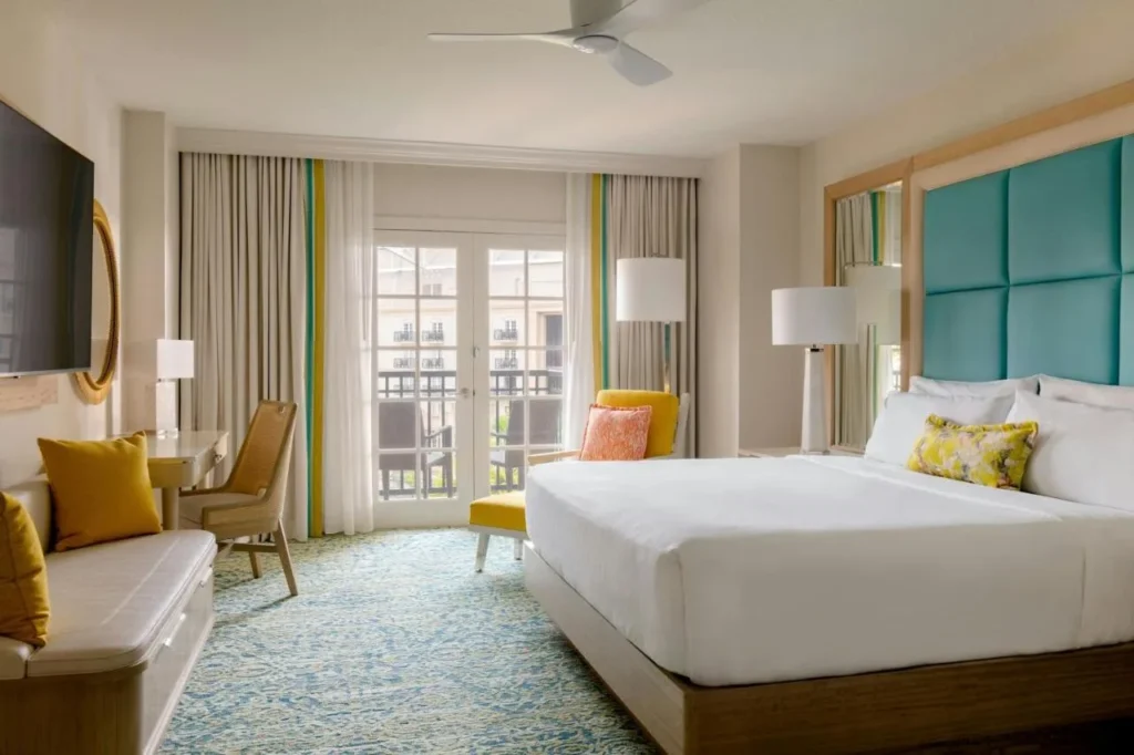King room with teal headboard and French doors to a balcony at Gaylord Palms