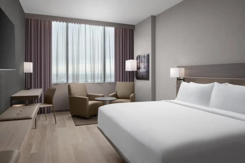 King room con dos sillones, un escritorio y una gran ventana en el AC Hotel Orlando Downtown