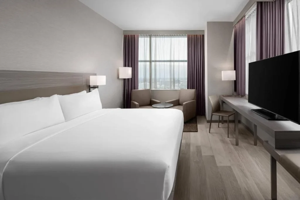 King room with two armchairs by a tall window at AC Hotel Orlando Downtown