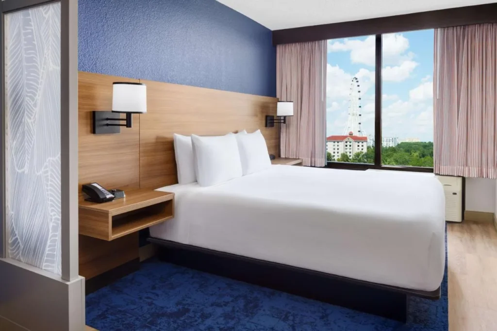 Habitaci&oacute;n con cama king y vista a la ventana de la rueda de observaci&oacute;n del Hyatt Place Orlando I-Drive Convention Center