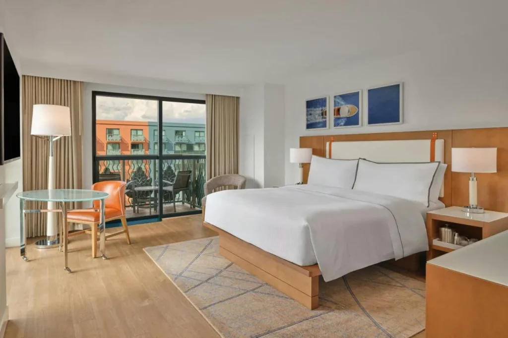 King room with wood floors and a balcony door at Walt Disney World Swan