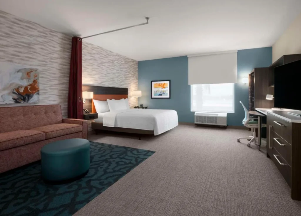 King studio suite with sofa, desk and large TV at Home2 Suites by Hilton Orlando South Davenport