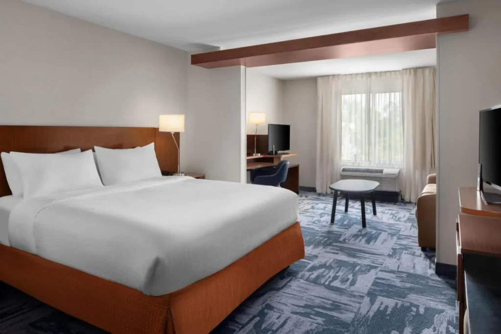 Suite con cama king size, zona de estar y escritorio en Fairfield Kissimmee/Celebration