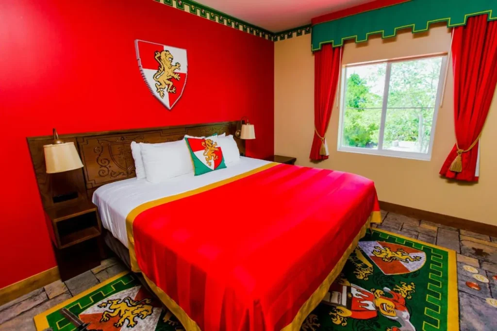 Kingdom-themed king room with red walls and a LEGO lion shield at the LEGOLAND Hotel