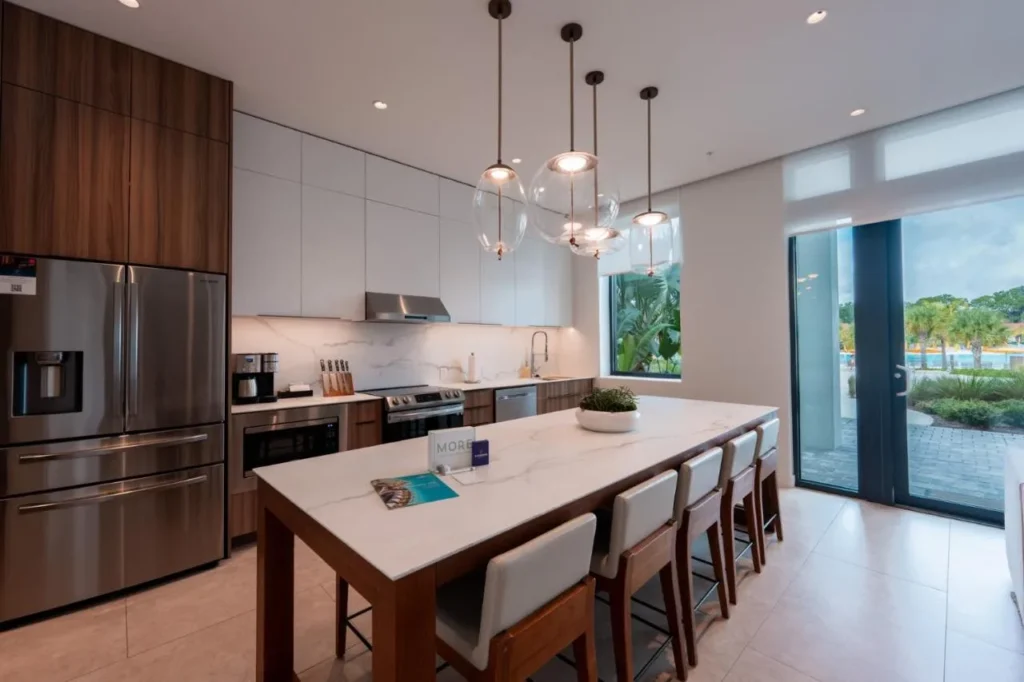 Kitchen with stainless-steel appliances and a long marble island in an Evermore Orlando Resort residence