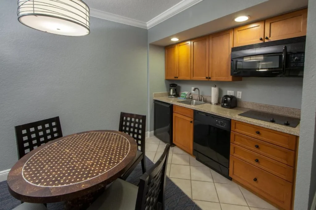 Kitchenette with a cooktop, microwave, dishwasher and round dining table at Orange Lake Resort