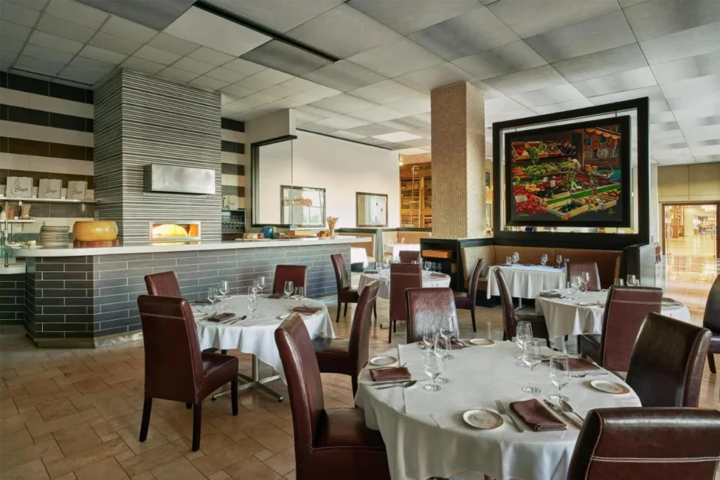 La Luce con su horno de pizza y mesas vestidas de blanco en Signia by Hilton Orlando Bonnet Creek