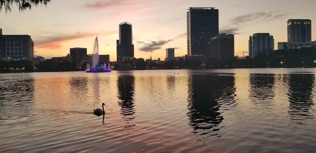 Fuente del Lake Eola y horizonte del centro de Orlando al atardecer con un cisne en el agua