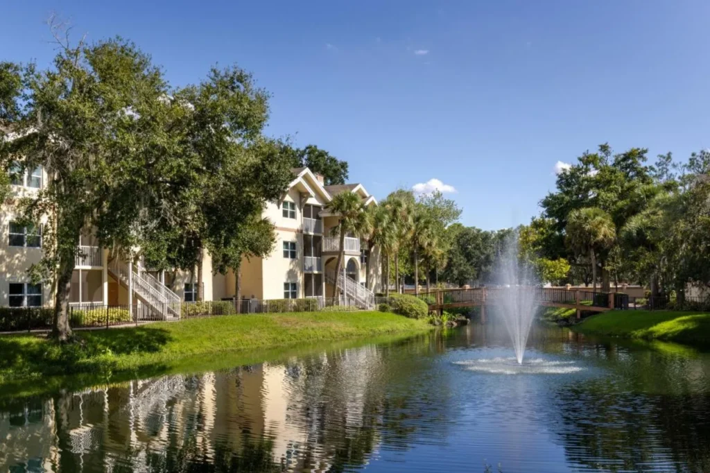 Lake fountain, footbridge and villa buildings under oak trees at Sheraton Vistana Resort