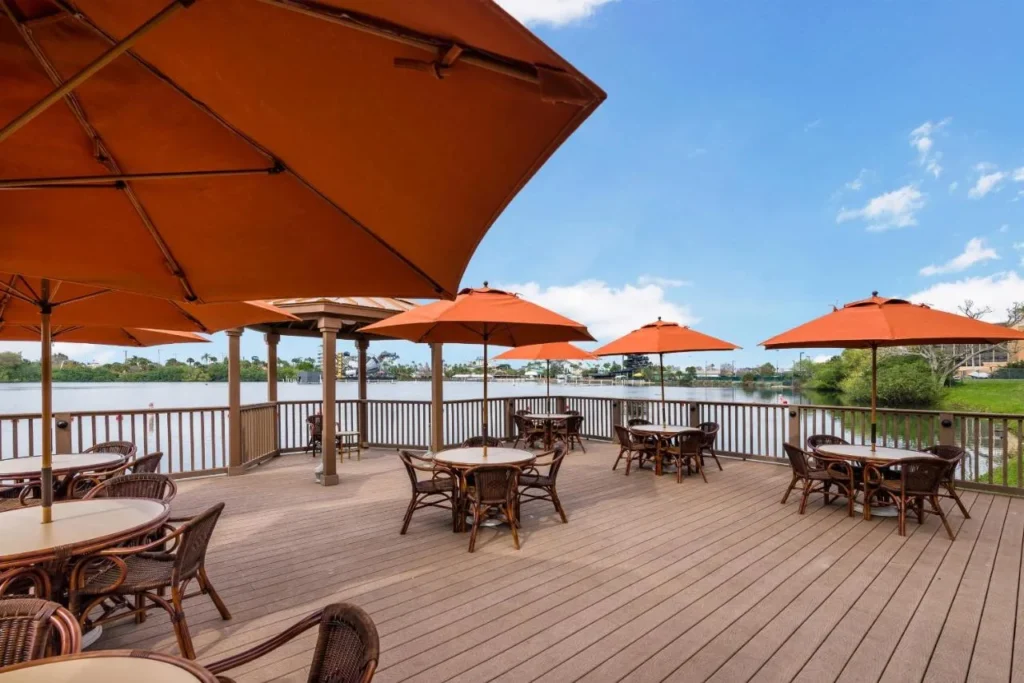 Lakeside deck with orange umbrellas and rattan chairs overlooking the water at Westgate Palace