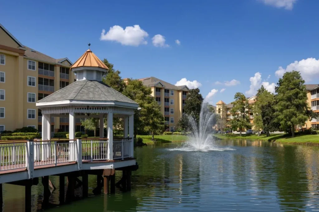 Gazebo y fuente junto al lago rodeados de edificios de villas amarillas en Sheraton Vistana Resort Villas