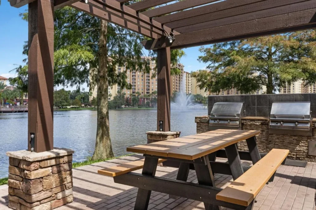 Mesa de picnic junto al lago y parrillas frente a la fuente y las torres en Club Wyndham Bonnet Creek