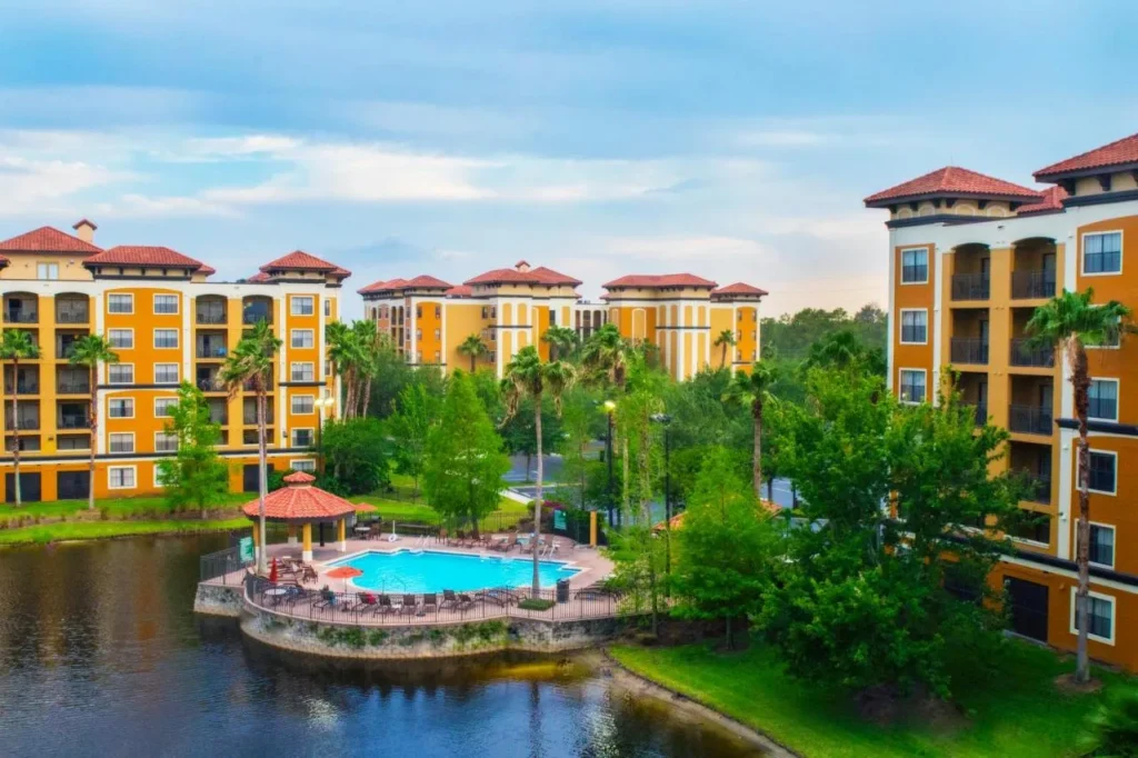 Piscina junto al lago y mirador con techo rojo entre los edificios de condominios en Floridays Resort Orlando