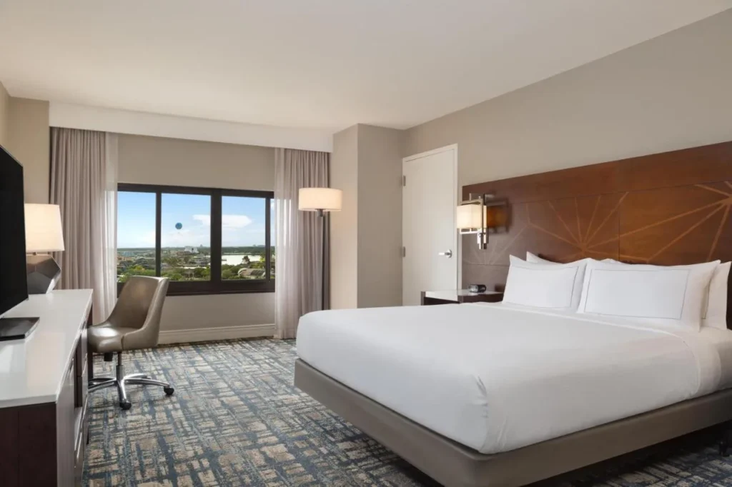 Large-bed room with a window toward Disney Springs at Hilton Orlando Lake Buena Vista