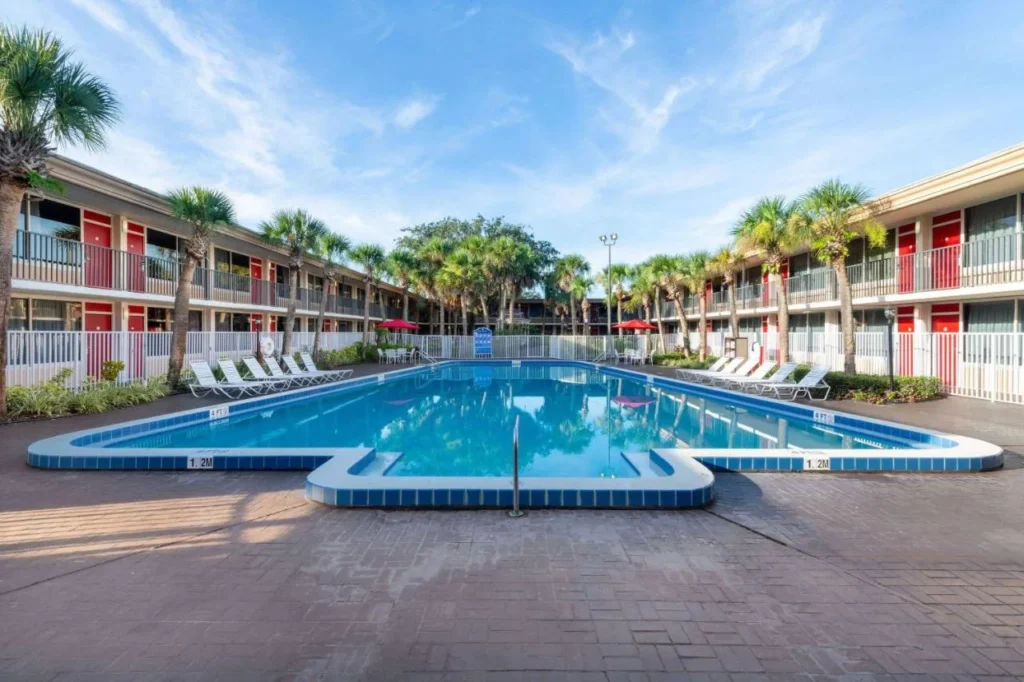 Gran piscina al aire libre entre las alas de la habitación de dos pisos en Ramada by Wyndham Kissimmee Gateway