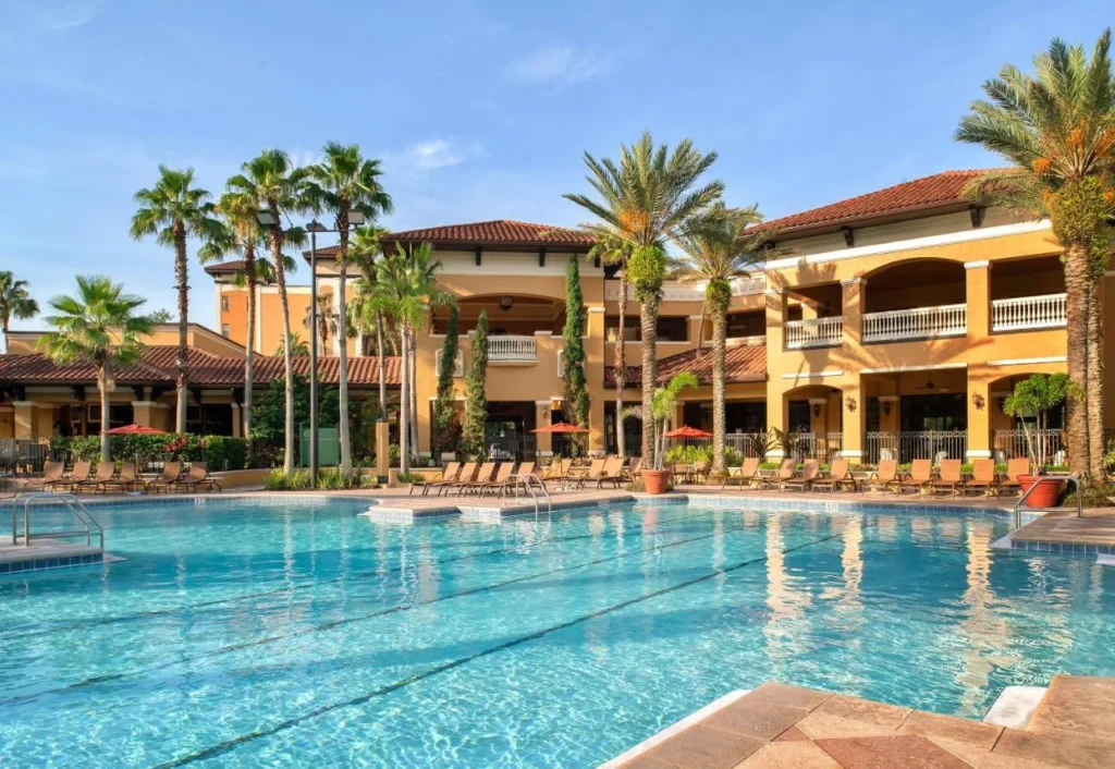 Gran piscina al aire libre frente a la casa club de estilo mediterráneo en Floridays Resort Orlando
