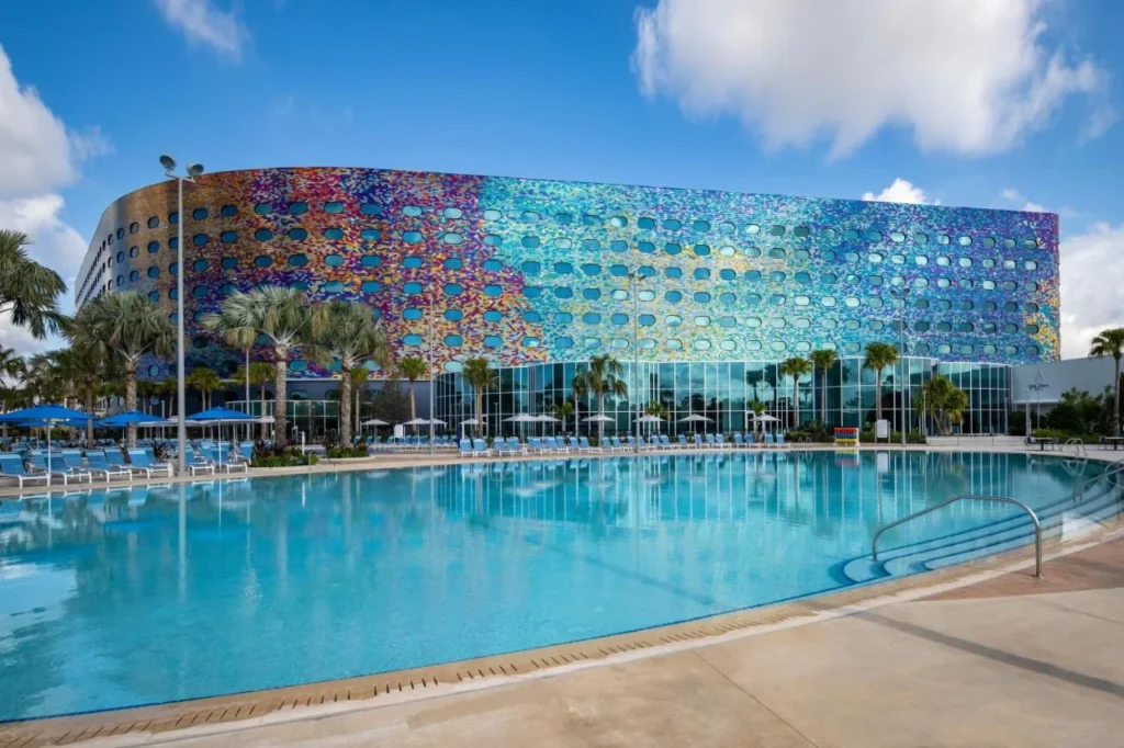 Large outdoor pool in front of the mosaic porthole facade of Universal Stella Nova Resort