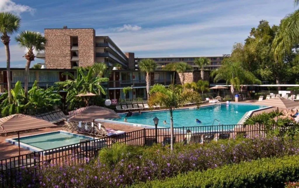 Large pool and a smaller pool surrounded by palm trees at Rosen Inn International