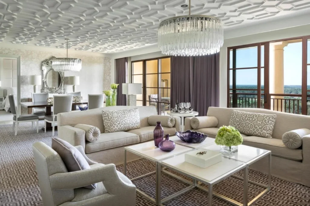 Large suite lounge with crystal chandeliers and a dining table at Four Seasons Resort Orlando