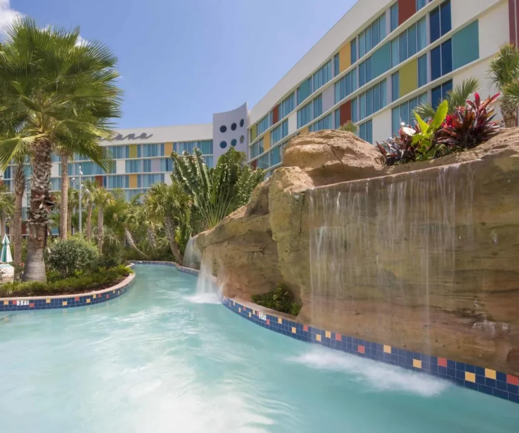 Lazy river flowing past a rock waterfall below a guest building at Cabana Bay Beach Resort