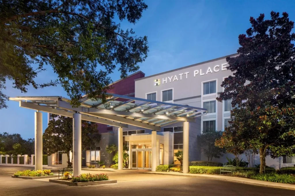 Lit entrance canopy and building sign of Hyatt Place Lake Mary/Orlando-North at dusk