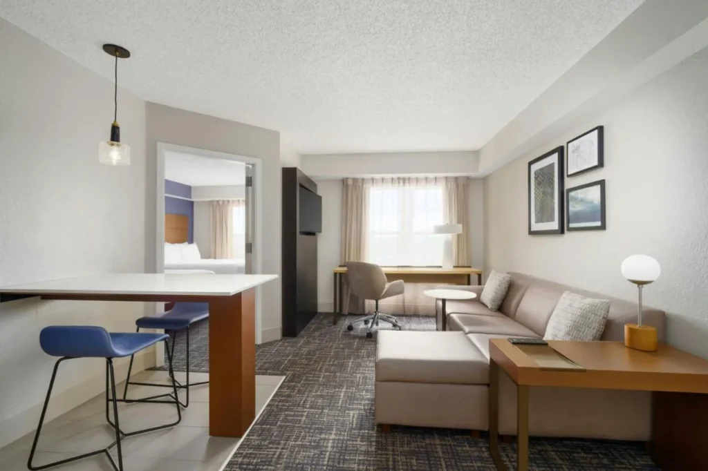 Living room with sofa, breakfast bar and bedroom doorway at Residence Inn Orlando Lake Buena Vista