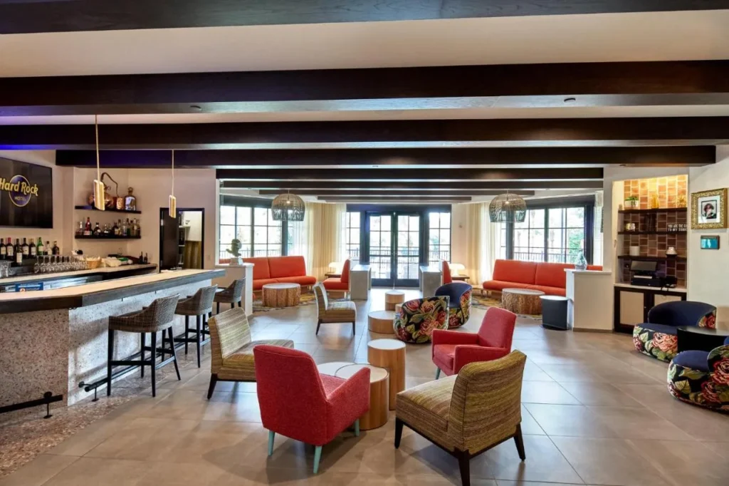 Lobby bar lounge with red armchairs, floral seats and tall windows at Hard Rock Hotel Orlando
