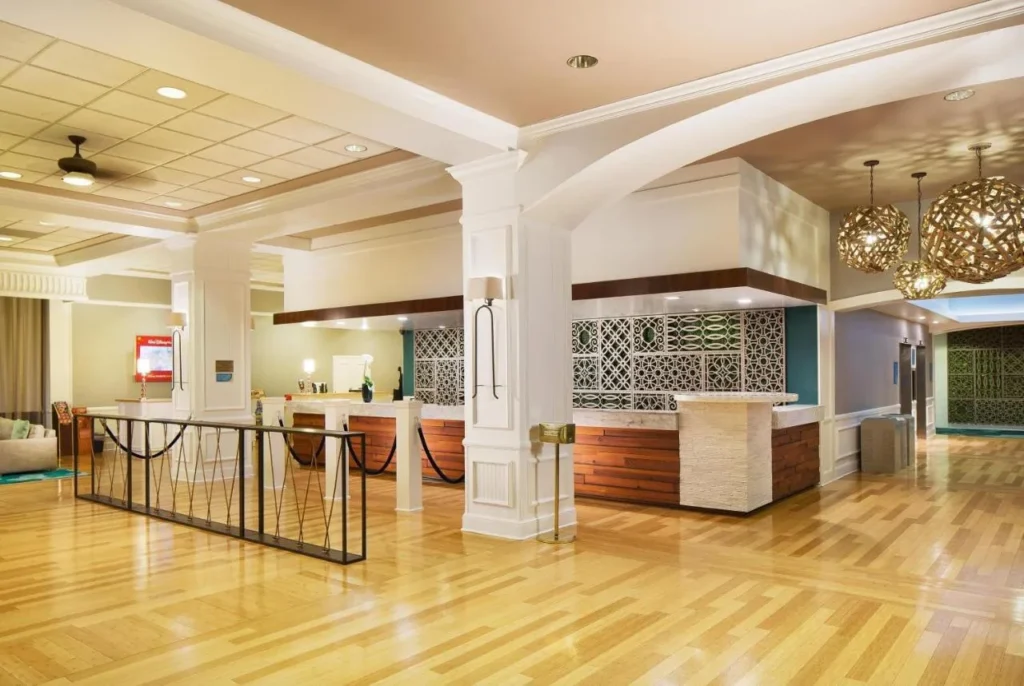 Lobby front desk with white columns and woven pendant lights at Wyndham Lake Buena Vista