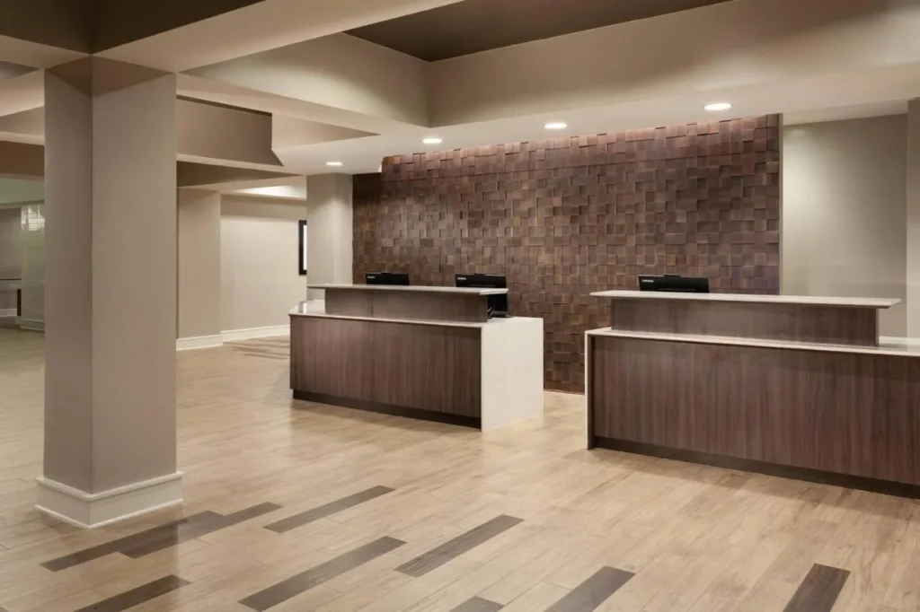Recepción en el vestíbulo con pared de paneles de madera y suelo de madera en el Residence Inn Orlando at SeaWorld