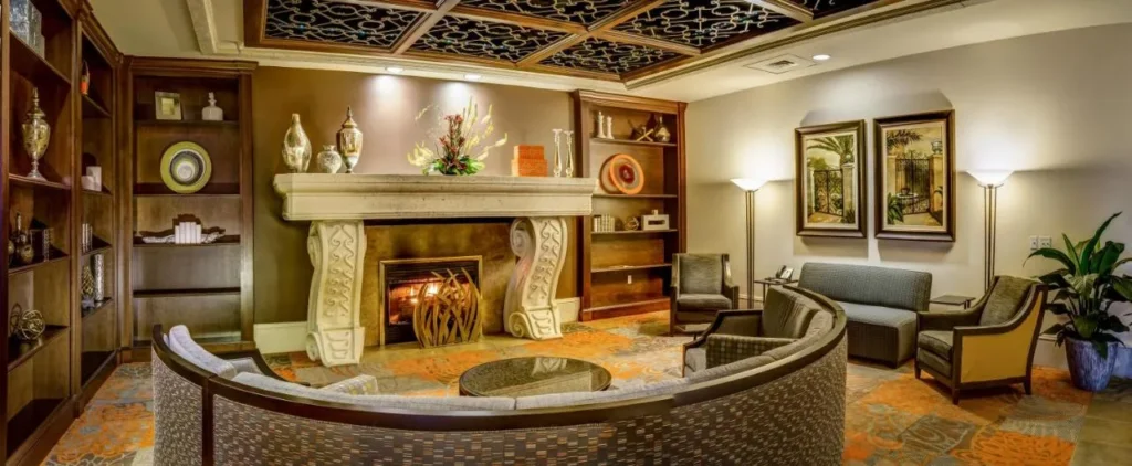 Lobby lounge with a carved stone fireplace and curved sofa at Rosen Shingle Creek