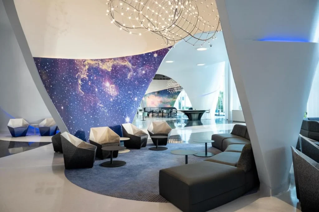 Sal&oacute;n del vest&iacute;bulo con un mural de galaxia estrellada y sillas esculpidas en el Stella Nova Resort de Universal