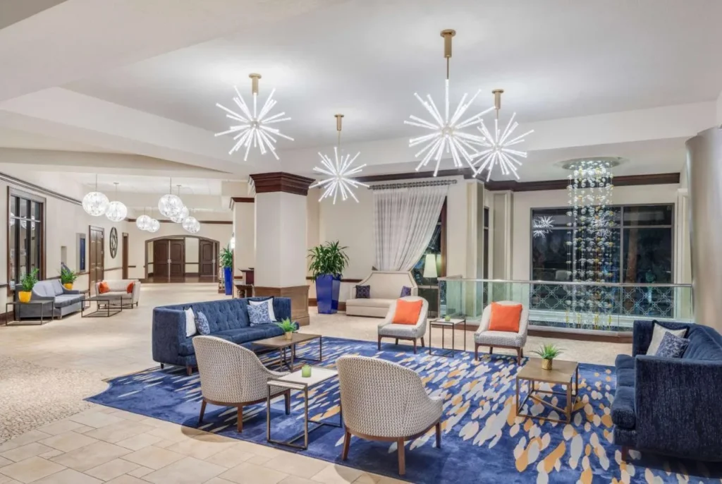Salón del vestíbulo con sofás azules y candelabros starburst en Wyndham Grand Orlando Bonnet Creek
