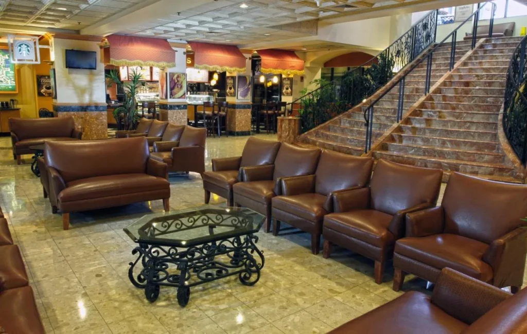 Lobby lounge with leather armchairs, marble staircase and coffee counter at Westgate Lakes Resort & Spa