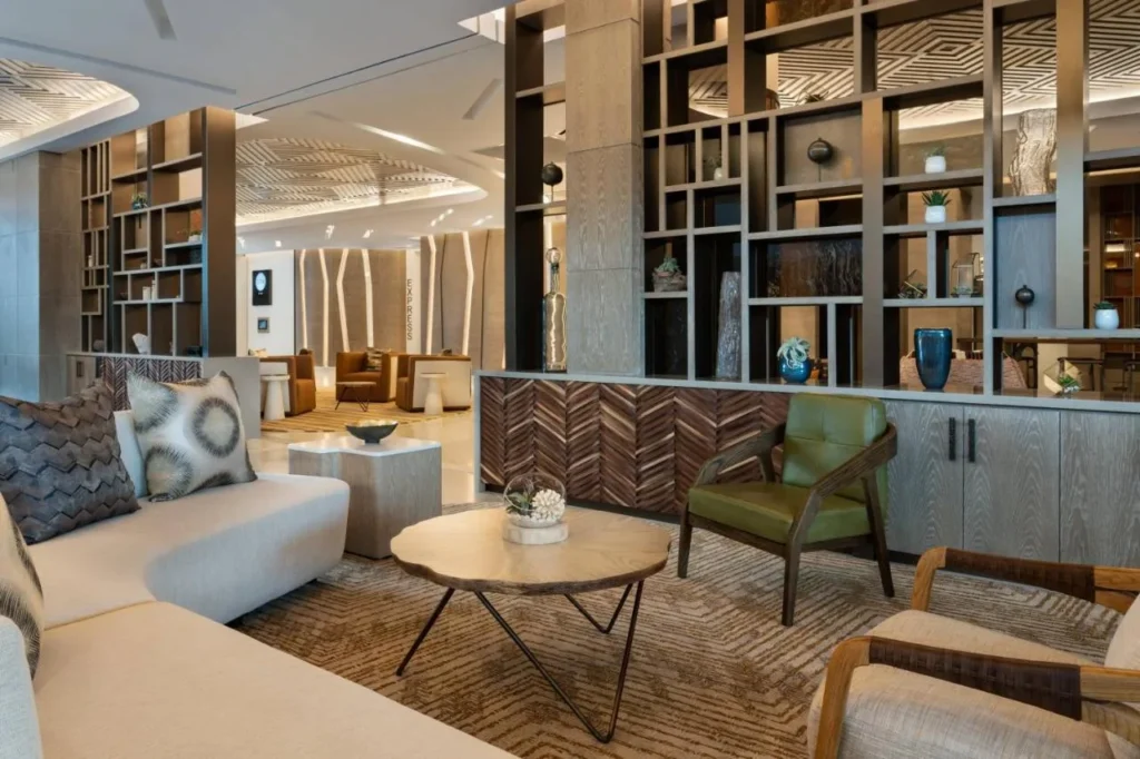 Lobby lounge with sofas, armchairs and tall wooden shelving at JW Marriott Orlando Bonnet Creek