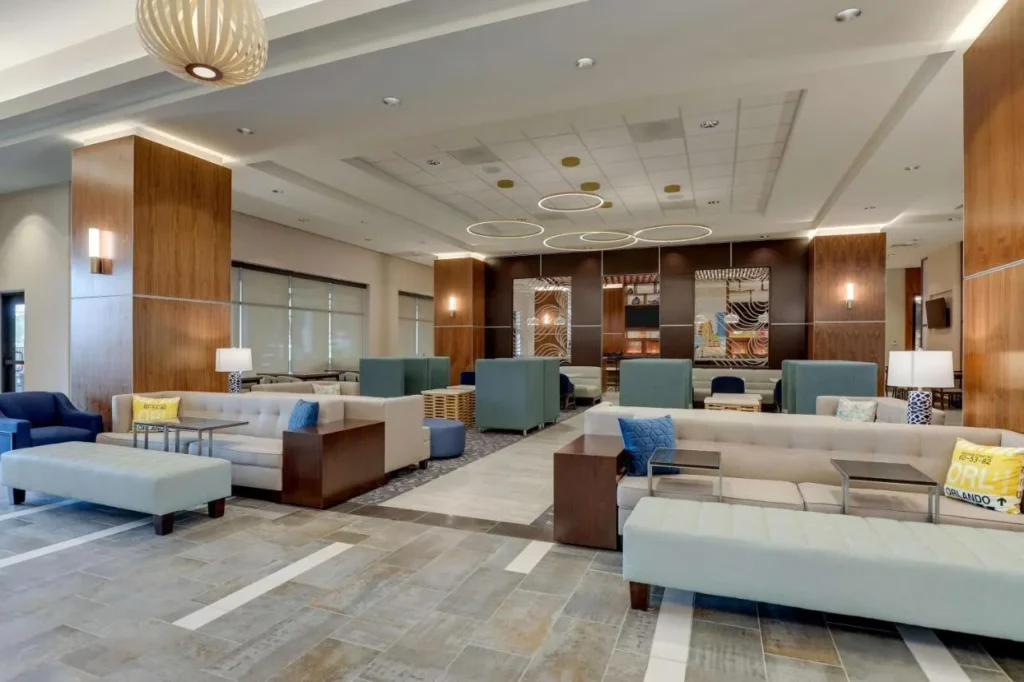 Lobby lounge with sofas, ottomans and ring chandeliers at Drury Plaza Hotel Orlando