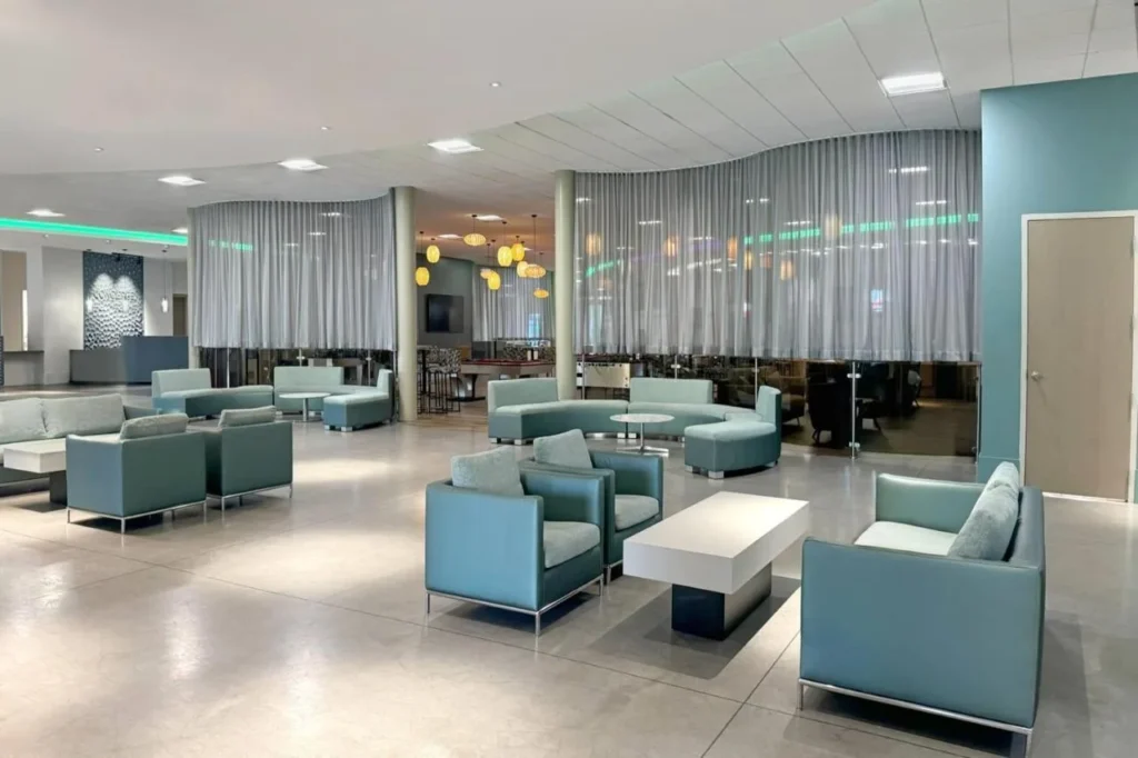 Lobby lounge with teal sofas and armchairs beside a curtained bar area at Wyndham I-Drive Avanti