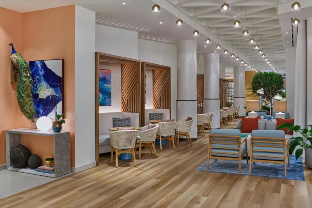 Lobby lounge with wood-slat booths and a peacock display, Walt Disney World Swan Reserve