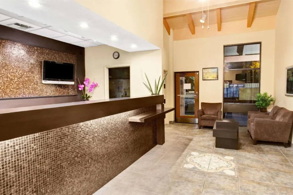 El Super 8 Kissimmee/Maingate cuenta con un vest&iacute;bulo con azulejos y sillones marrones.